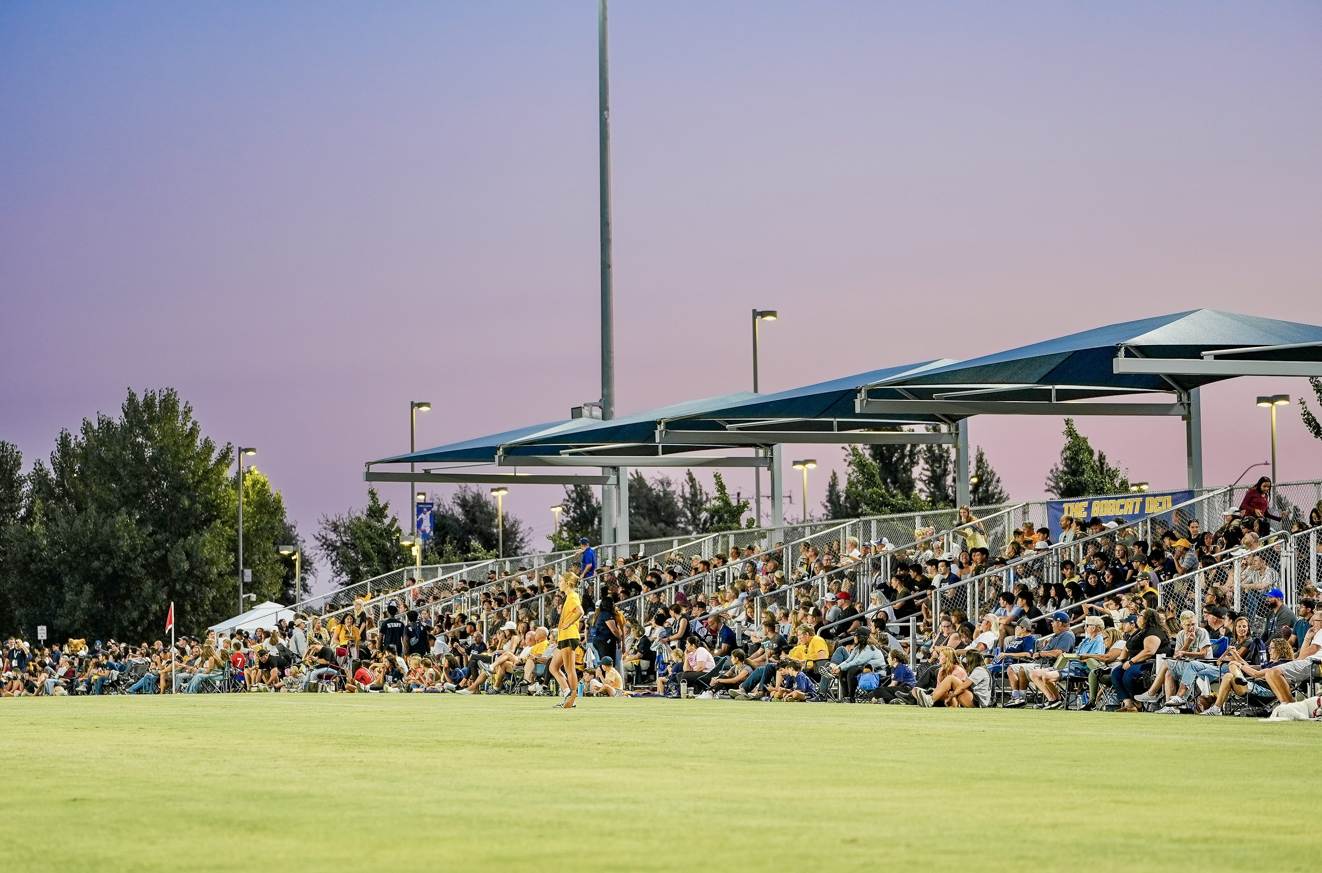 A family of six taking a group photo in front of the UC Merced sign